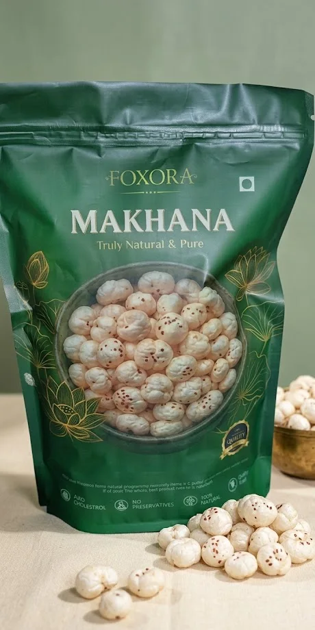 A green pack of Foxora makhana surrounded by loose makhana